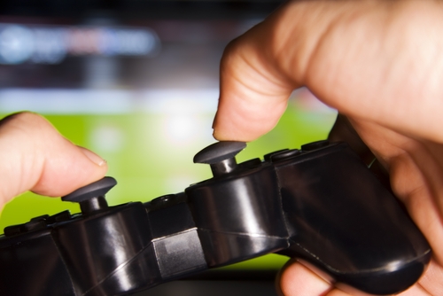 Gaming Industry Rentals A close up view of a pair of hands on a gaming controller