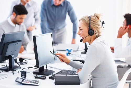 Telecommunication Industry Rentals A busy call center with a blond woman wearing a headset while working at a computer
