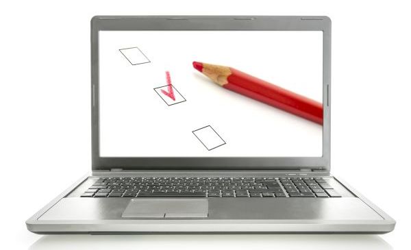 Campaign Industry Rentals A laptop with a screen displaying a checkbox filled out in red colored pencil, with the red pencil laying next to the checkbox