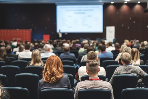 Corporate Event Production Rentals A crowd in an auditorium watching a presentation