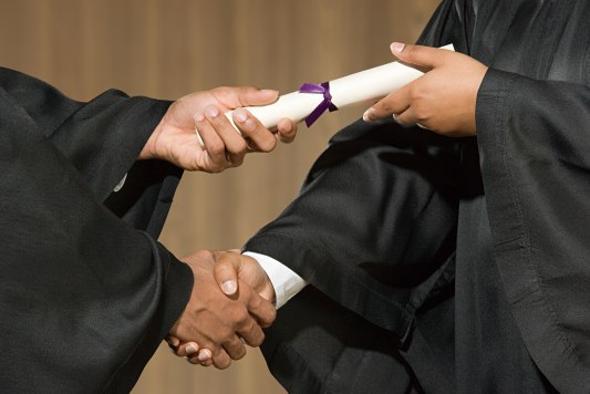 Graduation Event Rentals A diploma being handed to a graduate