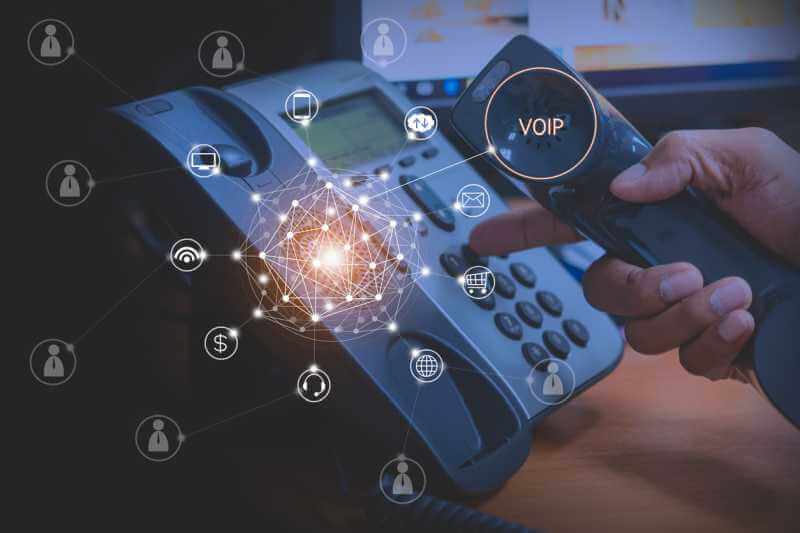 RingCentral IP Phones from Rentacomputer.com A hand holding a VOIP phone with a finger outreached to begin the dialing process