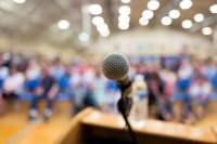 Sound System Rentals Services A podium with a microphone and a crowd of people waiting to listen
