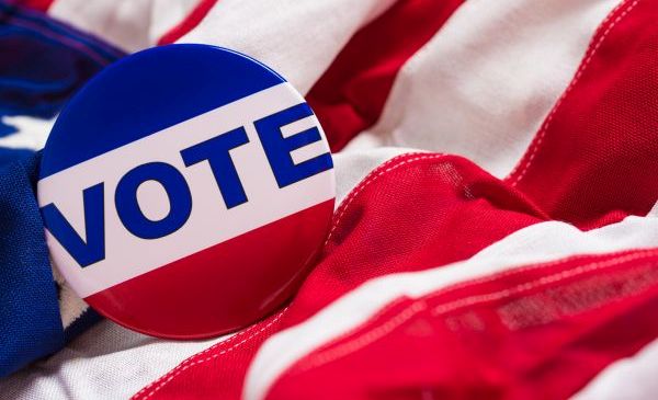 Campaign Rentals A button encouraging others to vote lays ontop of an American Flag